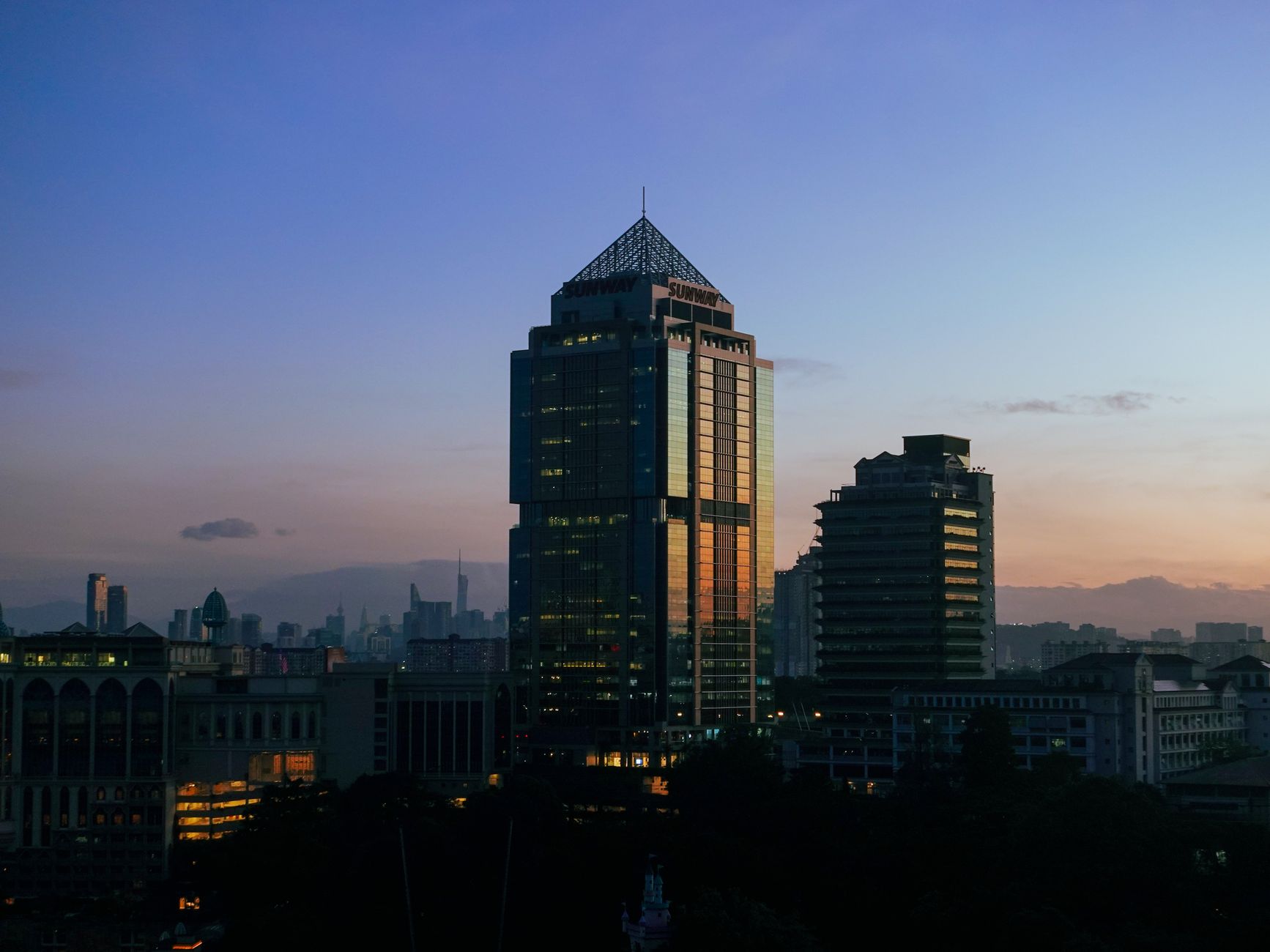 The Kuala Lumpur skyline at dusk seen from an upper-floor office